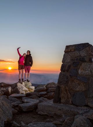 Couple take a selfie at the summit of Mount Kosciuszko in Kosciuszko National Park